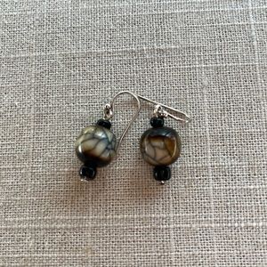 Hanging earring with small black beads and a larger brown bead-